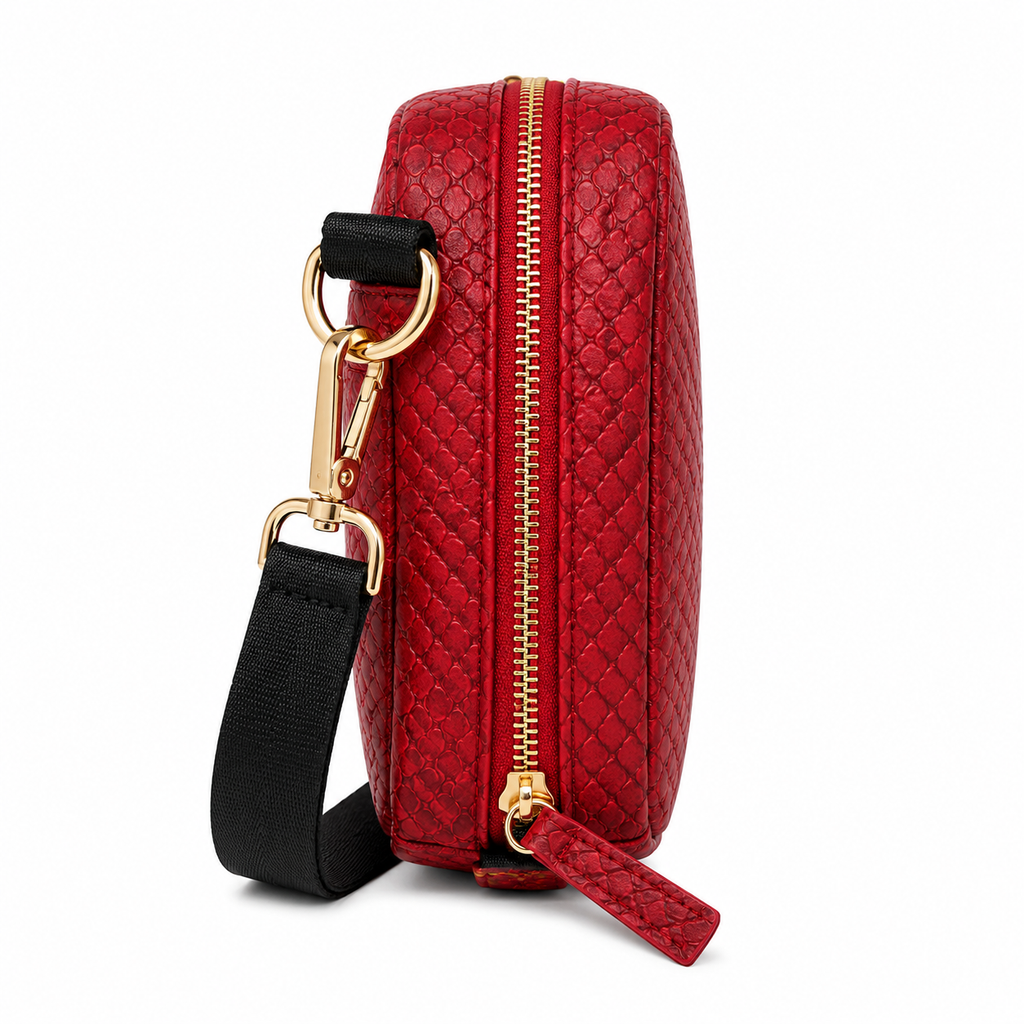 Red textured handbag with gold zipper and black strap on a white background